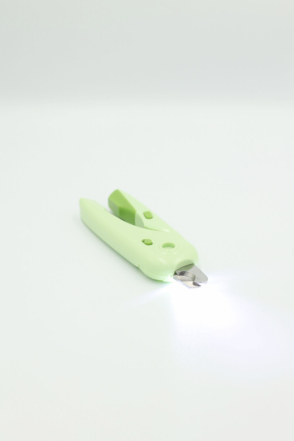 BudgetPaws LED Pet Nail Clippers in Budget Green with light turned on, photographed on a white background.
