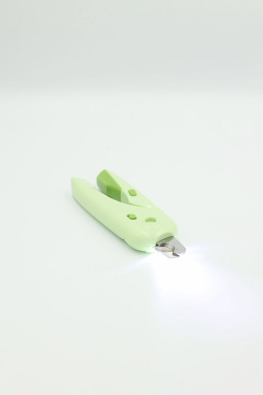 BudgetPaws LED Pet Nail Clippers in Budget Green with light turned on, photographed on a white background.
