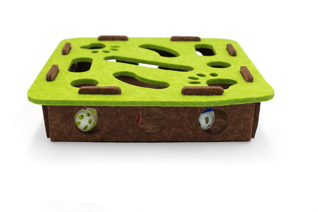 Close-up view of the green felt puzzle layers highlighting the smooth cutouts and interactive track openings.