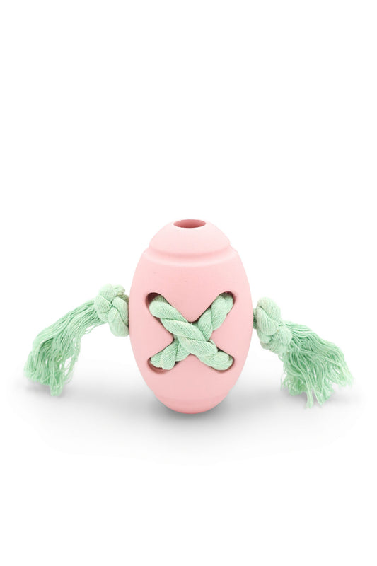 BudgetPaws Soft Petal rope-tied rugby ball dog toy in soft pink with green woven rope handle ends, photographed on a white background.